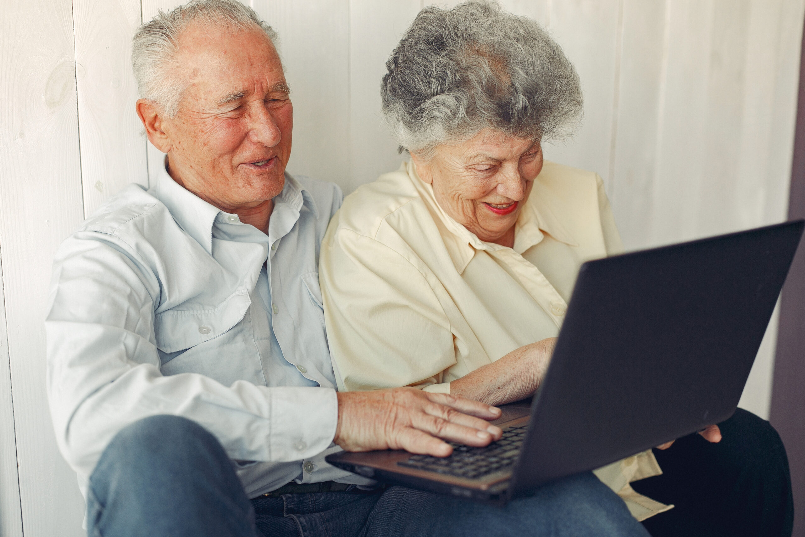 Senior couple consulting house insurance on their laptop.